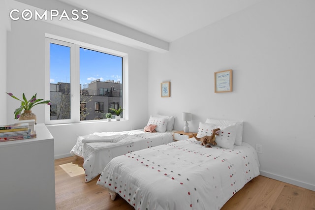 bedroom featuring wood finished floors and baseboards