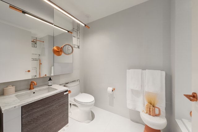 bathroom with toilet, vanity, and tile patterned floors