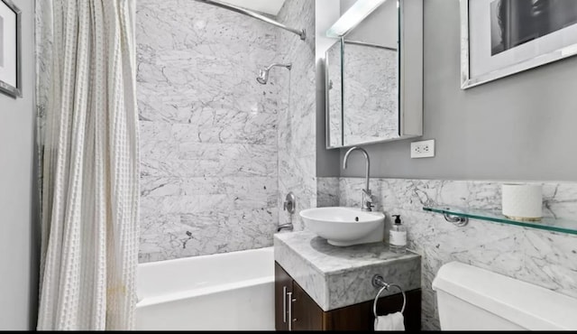 bathroom featuring toilet, shower / bath combo, vanity, and tile walls