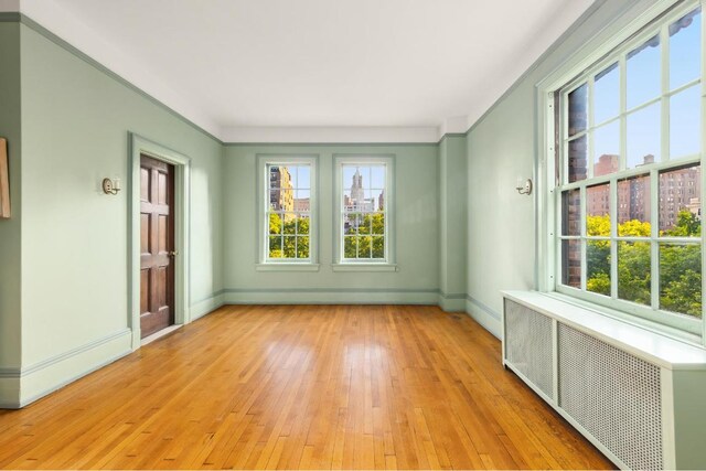 dining area featuring wood-type flooring and crown molding