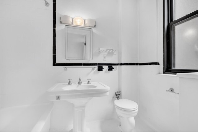 bathroom with toilet and tile walls