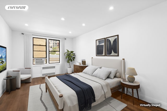 bedroom with cooling unit, dark hardwood / wood-style flooring, and radiator heating unit