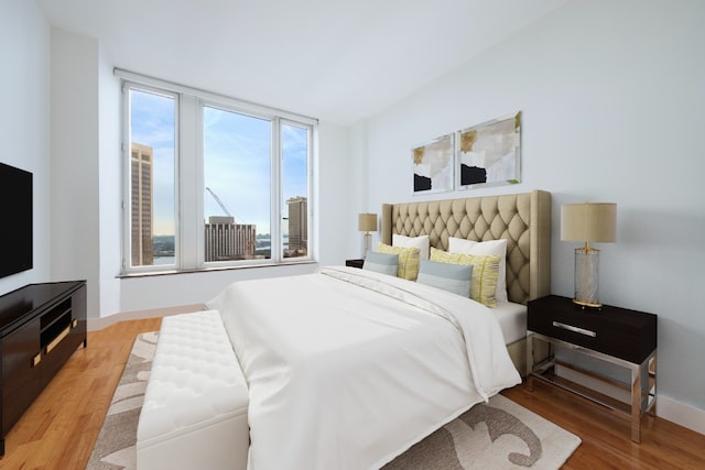 bedroom with lofted ceiling and light hardwood / wood-style flooring