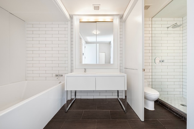 full bathroom featuring vanity, tile patterned flooring, toilet, and separate shower and tub