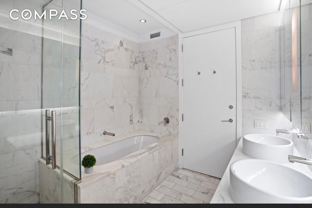 bathroom featuring a sink, visible vents, marble finish floor, and a bath