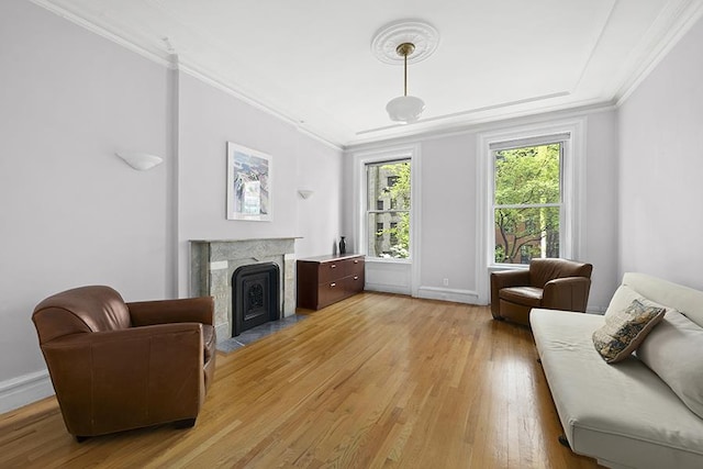 living area featuring crown molding, a high end fireplace, and light hardwood / wood-style flooring