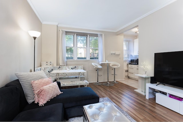 living room featuring light wood-type flooring, baseboards, and ornamental molding