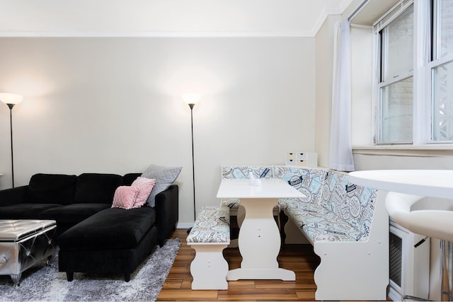 living area with plenty of natural light, wood finished floors, and ornamental molding