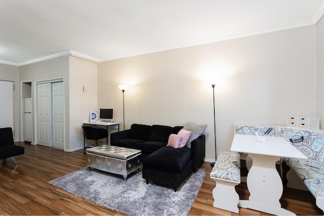 living room with baseboards, wood finished floors, and crown molding