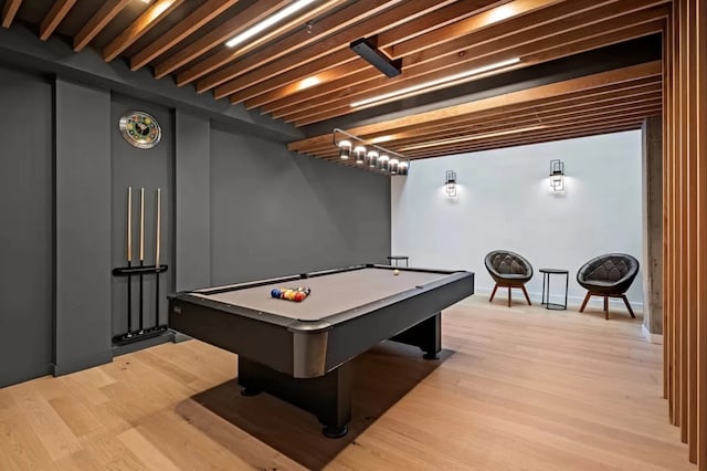 game room with pool table, beam ceiling, and light hardwood / wood-style flooring