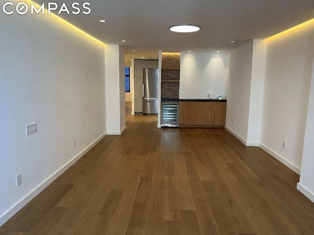 unfurnished living room with wine cooler and dark hardwood / wood-style flooring