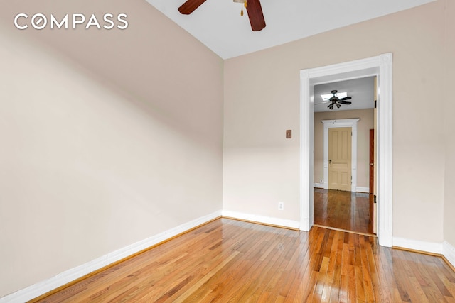 empty room featuring baseboards, a ceiling fan, and hardwood / wood-style flooring