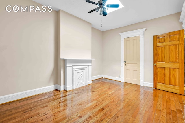 interior space featuring light wood-type flooring, baseboards, and a ceiling fan