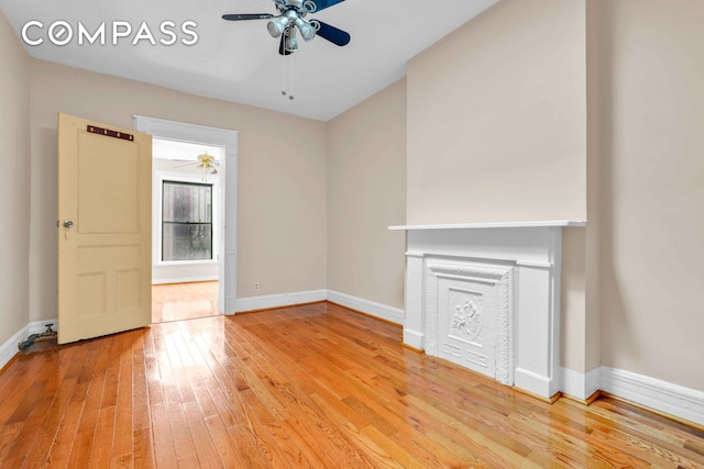 unfurnished living room featuring light wood-style flooring, baseboards, and ceiling fan