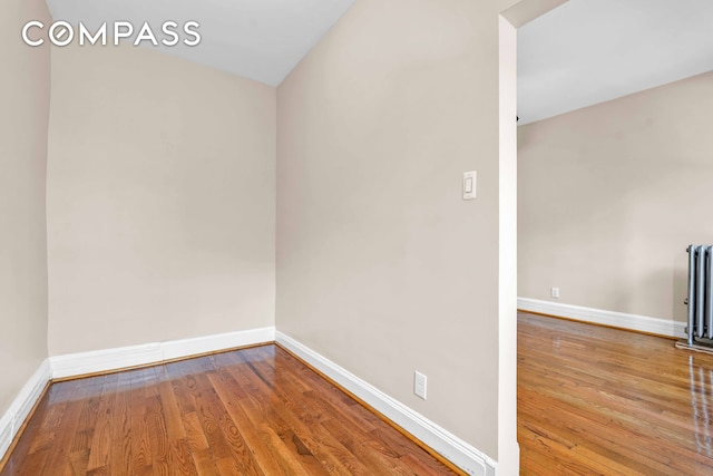 unfurnished room with baseboards and wood finished floors