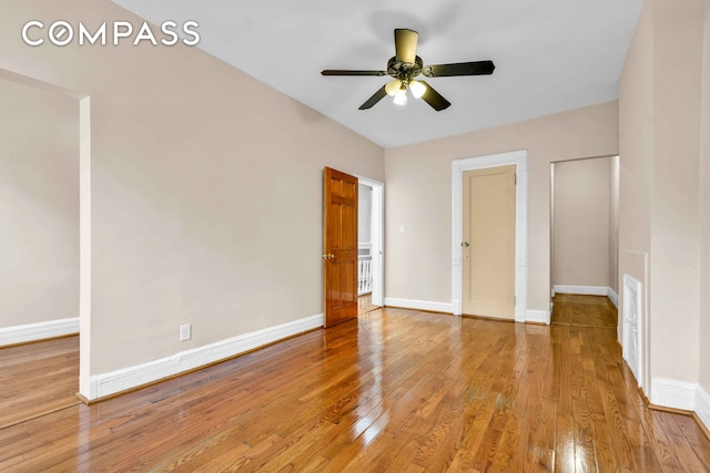 unfurnished bedroom featuring baseboards, a ceiling fan, visible vents, and light wood finished floors