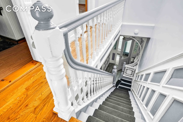 stairs featuring wood finished floors
