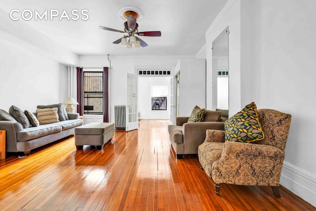 living area featuring ceiling fan, hardwood / wood-style floors, and radiator