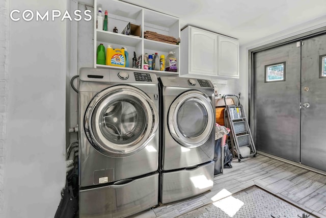 clothes washing area with washing machine and dryer, cabinet space, and wood finish floors