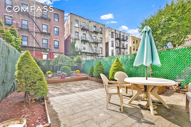 view of patio featuring outdoor dining area and fence