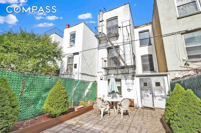 back of house featuring stucco siding, fence, and a patio area