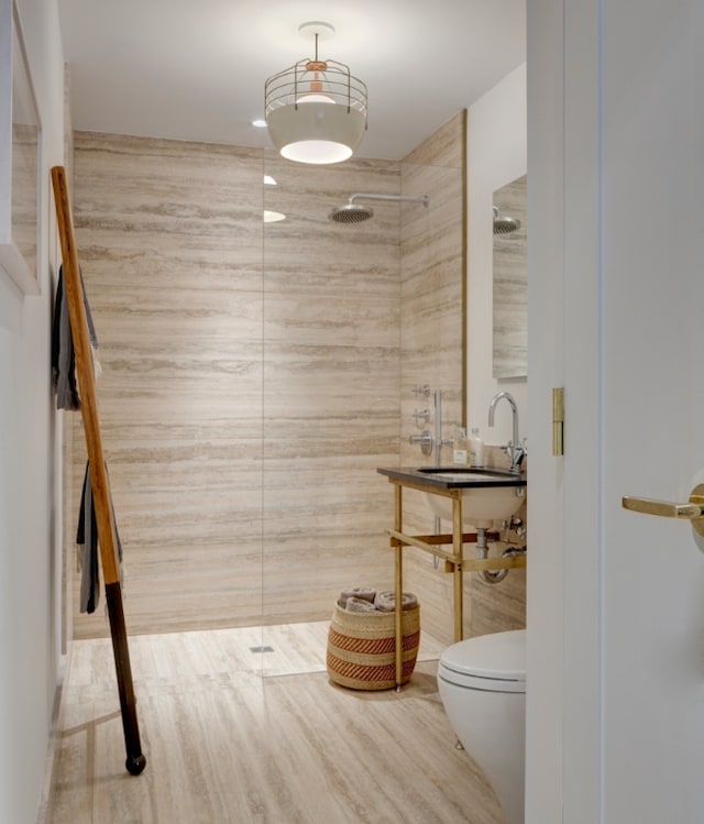 bathroom with a shower, sink, and toilet