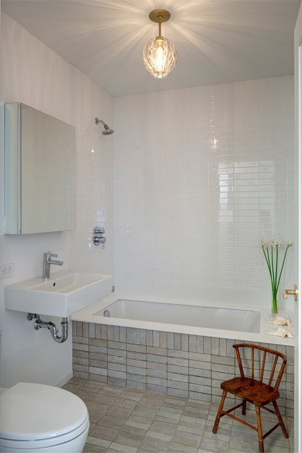 bathroom with toilet and tiled shower / bath combo