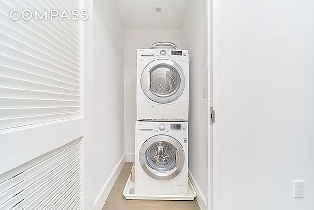 clothes washing area featuring stacked washer and dryer