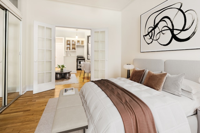 bedroom with french doors, a closet, and wood-type flooring