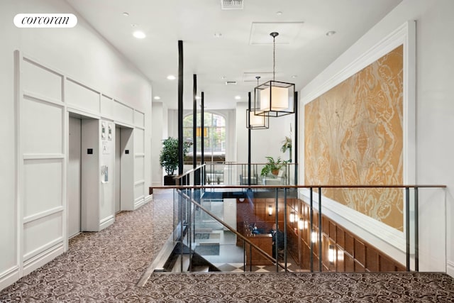 corridor with elevator, an upstairs landing, recessed lighting, and baseboards