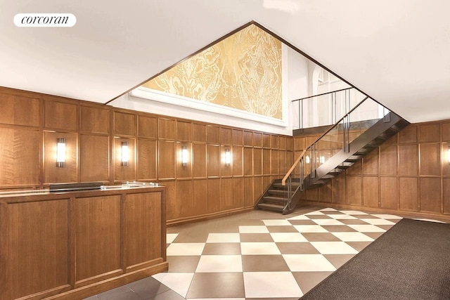 interior space featuring stairway, wooden walls, and a decorative wall