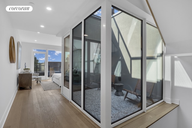 hallway with visible vents, recessed lighting, baseboards, and wood-type flooring