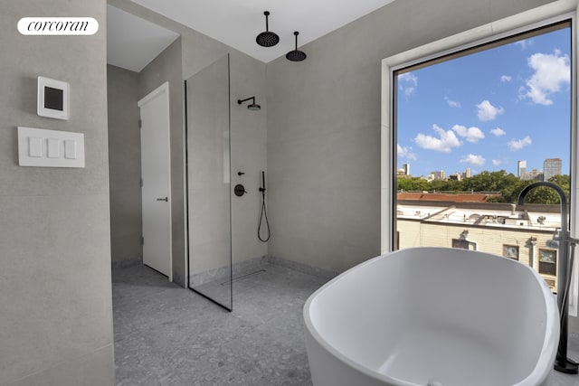 bathroom featuring a view of city, a freestanding tub, and walk in shower