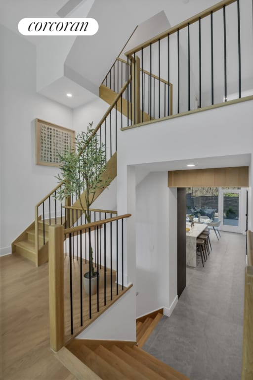 stairs featuring a high ceiling and hardwood / wood-style floors