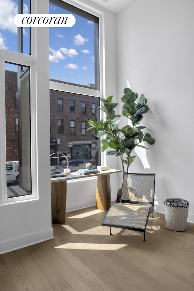 interior space featuring a high ceiling, wood finished floors, and baseboards