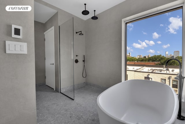 bathroom with shower with separate bathtub and plenty of natural light