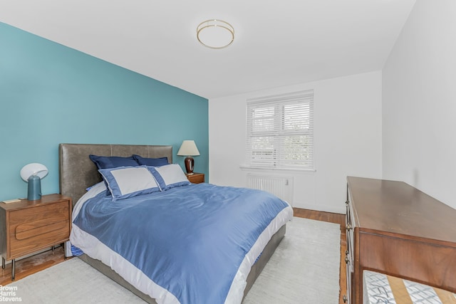 bedroom featuring radiator heating unit and wood finished floors