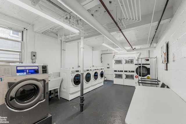 common laundry area featuring washer and dryer and concrete block wall