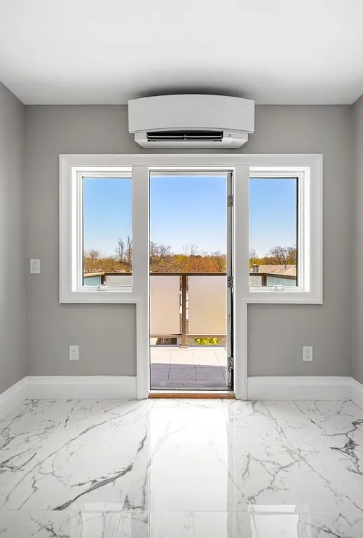 doorway to outside featuring a wall mounted AC and plenty of natural light