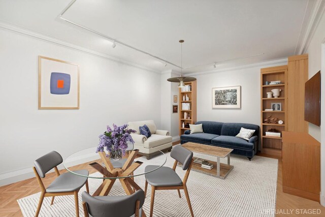 living room featuring rail lighting, ornamental molding, and light parquet flooring