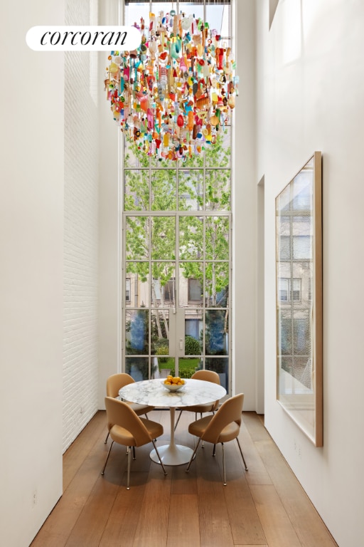 dining area with hardwood / wood-style floors and a towering ceiling