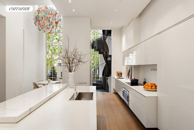 kitchen featuring light stone counters, floor to ceiling windows, and white cabinets