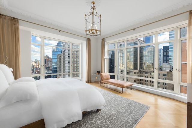 bedroom featuring a city view, an inviting chandelier, and access to outside