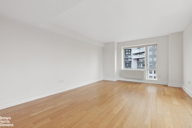 empty room featuring baseboards and light wood-style flooring