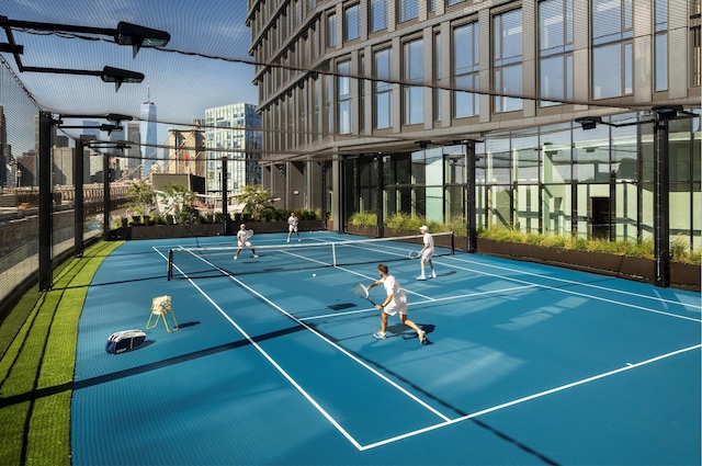 view of tennis court featuring a city view, community basketball court, and fence