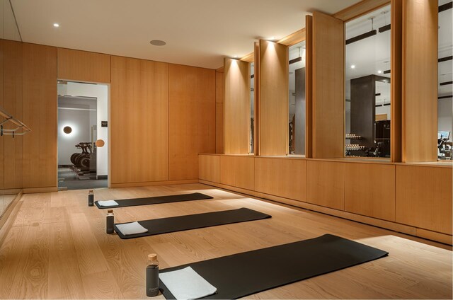 exercise area with wooden walls and wood finished floors