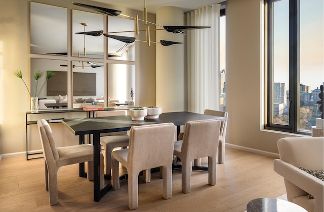 dining area with light wood-style flooring, plenty of natural light, and a chandelier