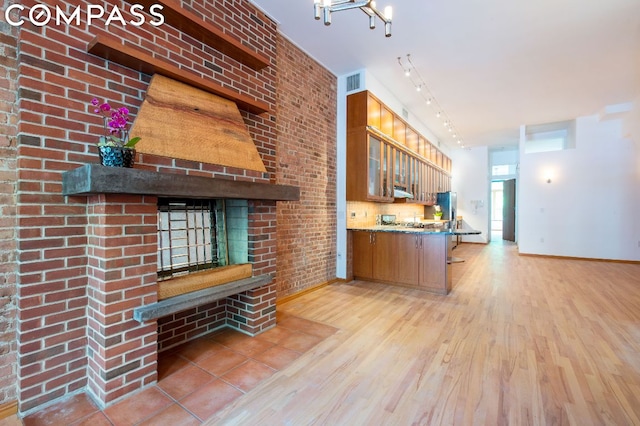 kitchen featuring a breakfast bar area, kitchen peninsula, and light hardwood / wood-style flooring