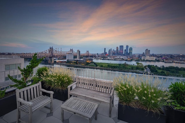 patio terrace at dusk featuring a water view