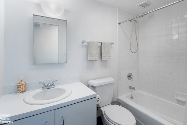 full bathroom featuring toilet, tiled shower / bath combo, and vanity